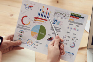 hand pointing to charts financials